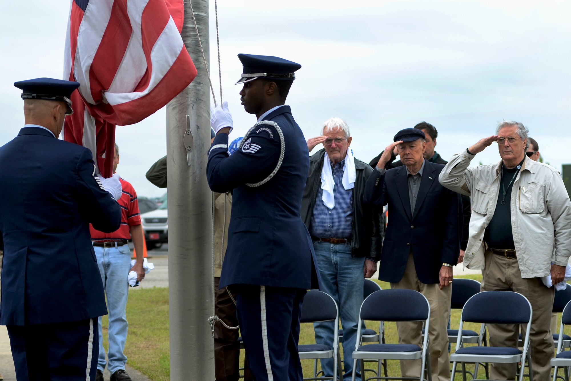 U.S. Air Force retired fighter pilots from the South Carolina Air National Guard, salute the U.S. flag as it is raised during a pilot reunion ceremony at McEntire Joint National Guard Base, Eastover, S.C., May 4, 2013. Multi-generation SCANG pilots dating back from the P-51 propeller fighter era to present converged to honor fallen comrades and celebrate their experiences and contributions to fighter operations and the legacy of the SCANG Swamp Foxes.  (U.S. Air National Guard photo by Tech. Sgt. Caycee Watson/Released)