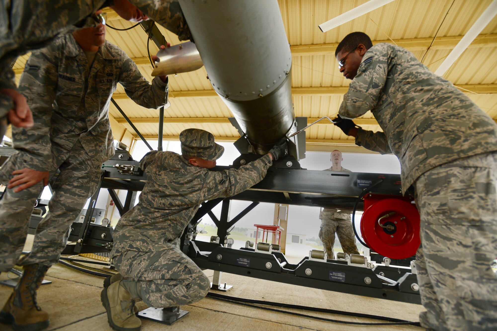 U.S. Air Force Airman 1st Class Jonathan Bass, 20th Fighter Wing Public Affairs photojournalist, secures fins on a Guided Bomb Unit 31, version 3, during a tour of the bomb dump, Shaw Air Force Base, S.C., May 3, 2013. The purpose of the tour was to bring Airmen from outside the career field in to experience bomb building. During the tour of the bomb dump, Airmen were shown how to build dummy bombs and missiles and had a chance to build them as well. (U.S. Air Force photo by Senior Airman Tabatha Zarrella/Released)
