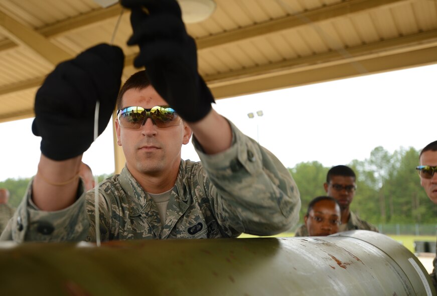 U.S. Air Force Airman 1st Class Joshua Wagner, 20th Comptroller Squadron financial manager, uses an arming wire to pull up the fuse for the Guided Bomb Unit 31, version 3, during a tour of the bomb dump, Shaw Air Force Base, S.C., May 3, 2013. The purpose of the tour was to bring Airmen from outside the career field in to experience bomb building. During the tour of the bomb dump, Airmen were shown how to build dummy bombs and missiles and had a chance to build them as well. (U.S. Air Force photo by Senior Airman Tabatha Zarrella/Released)
