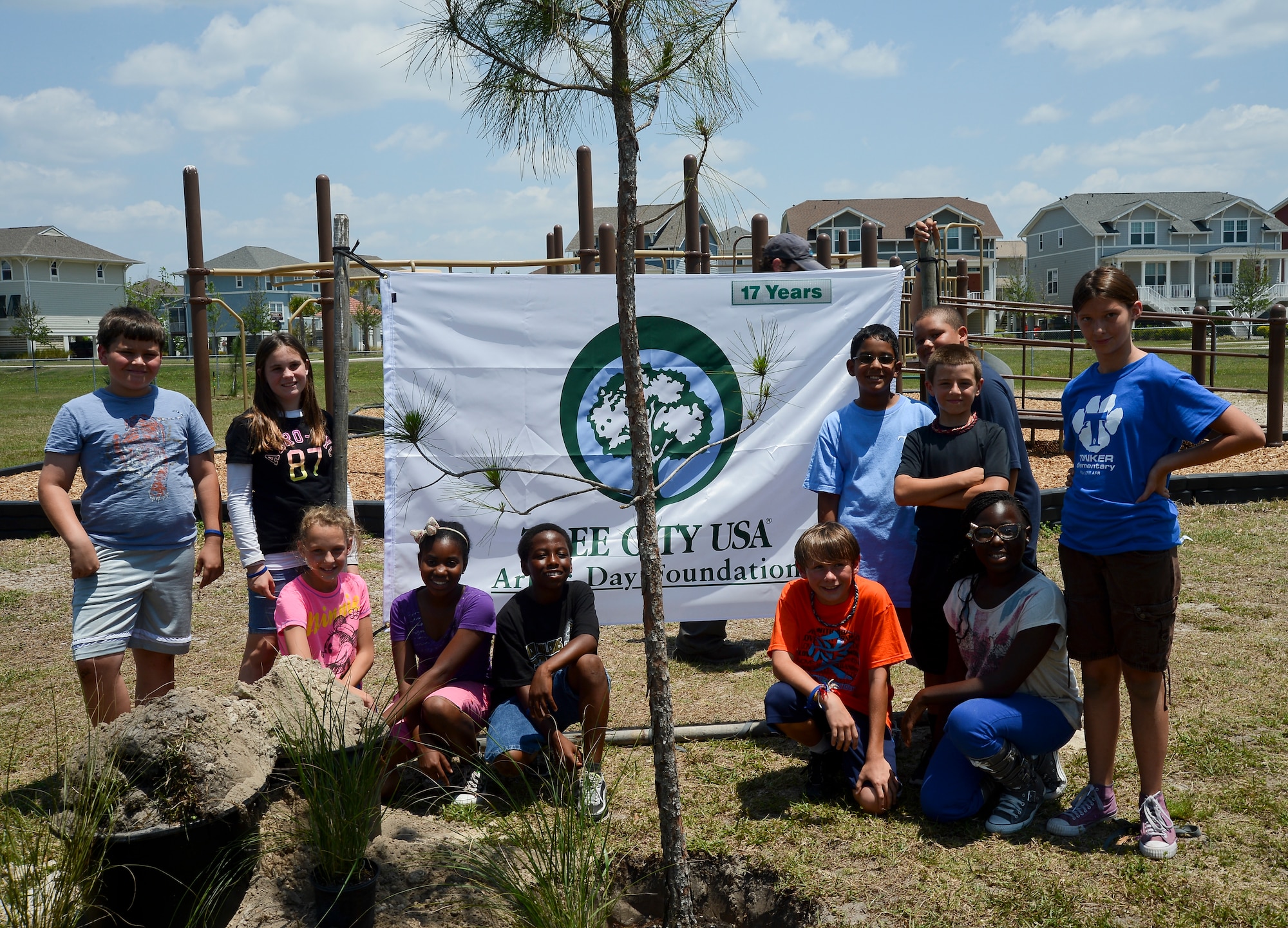 Tinker Elementary School 5th graders pose for a photo after planting trees around the school playground during an Arbor Day ceremony at MacDill Air Force Base, Fla. on April 26, 2013. MacDill has partnered with the Arbor Day Foundation Tree City USA program that provides the framework for community forestry management for cities and towns across America.(U.S. Air Force photo by Senior Airman Shandresha Mitchell/ Released)