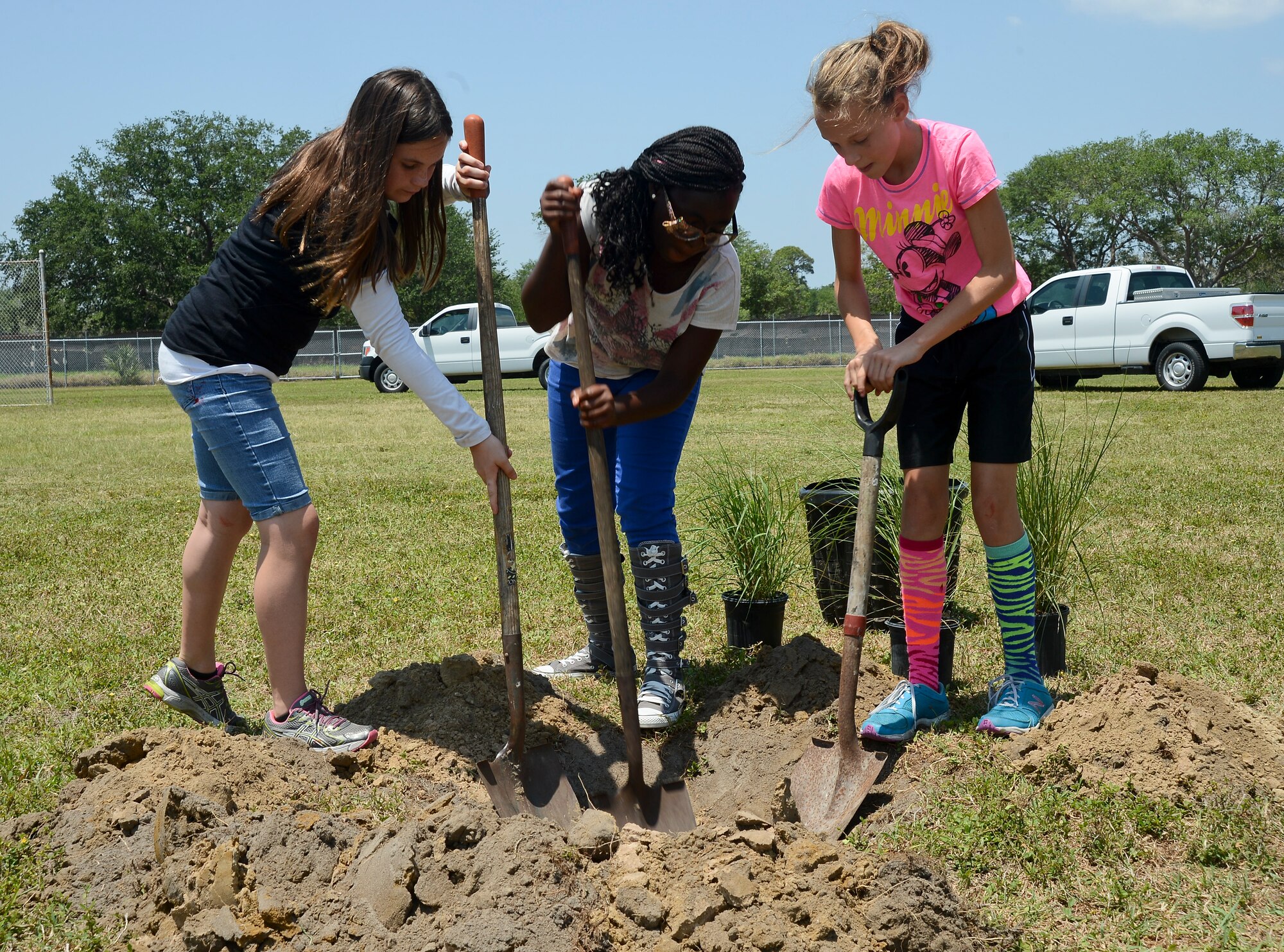 Tinker Elementary School 5th graders shovel dirt while planting trees around the school playground during an Arbor Day ceremony at MacDill Air Force Base, Fla. on April 26, 2013. MacDill has partnered with the Arbor Day Foundation Tree City USA program that provides the framework for community forestry management for cities and towns across America. (U.S. Air Force photo by Senior Airman Shandresha Mitchell/ Released)