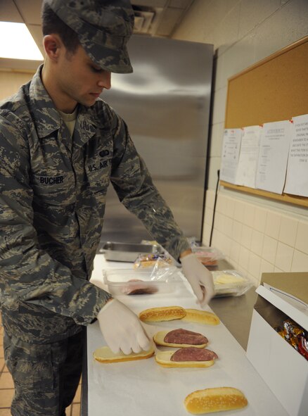 Airman 1st Class Michael Bucher, 2nd Force Support Squadron food services, makes a sandwich for a to-go box at the Touch-N-Go flight kitchen on Barksdale Air Force Base, La., May 6, 2013. The flight kitchen serves breakfast from 6 to 8 a.m., lunch from 11 a.m. to 1:30 p.m. and dinner from 3:30 to 7 p.m. After dinner, the flight kitchen's dining room is closed but Airmen are still able to order box meals from the pick-up window. (U.S. Air Force photo/Airman 1st Class Benjamin Gonsier)
