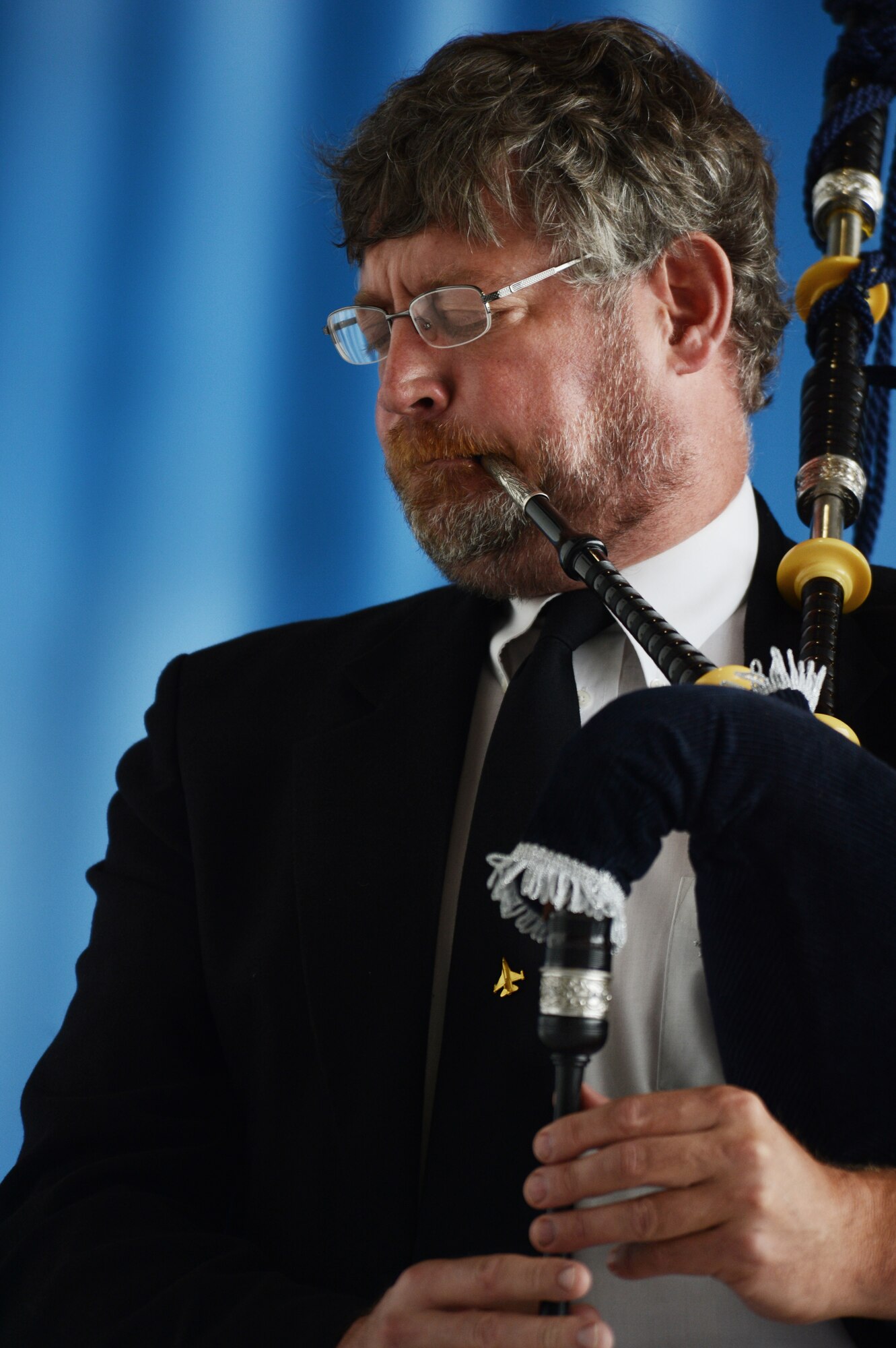 Retired U.S. Air Force Col. Robert Hopkins plays "Amazing Grace" with a bagpipe during a memorial held for Capt. James Steel, 77th Fighter Squadron pilot, in Hangar 1200 at Shaw Air Force Base, S.C., April 30, 2013. More than 450 people attended the memorial. Steel passed away when his F-16 Fighting Falcon crashed in Afghanistan April 3, 2013. (U.S. Air Force photo by Senior Airman Tabatha Zarrella/Released)
