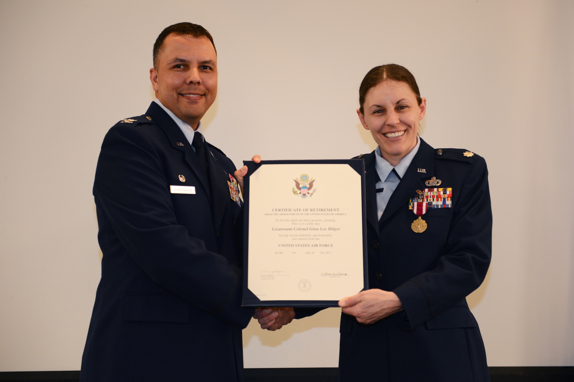 Col. Patrick Shortsleeve, 497th Intelligence, Surveillance and Reconnaissance Group commander, presents Lt. Col. Gina Hilger, U.S. Air Forces Central deputy director of intelligence, with her certificate of retirement at Shaw Air Force Base, S.C., April 26, 2013. Hilger is a native of Maryville, Ill., and has served in the U.S. Air Force for 20 years. (U.S. Air Force photo by Airman 1st Class Krystal M. Jeffers/Released)