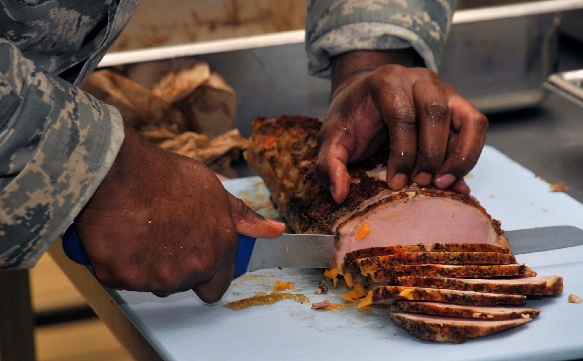 U.S. Air Force Staff Sgt. Andre Lewis, 35th Force Support Squadron food services shift leader, prepares servings of pork in the Grissom Dining Facility kitchen at Misawa Air Base, Japan, April 18, 2013. Customers are given the opportunity to have meals at the dining facility that provide nutrition from all of the different food groups. (U.S. Air Force photo by Airman 1st Class Zachary Kee)