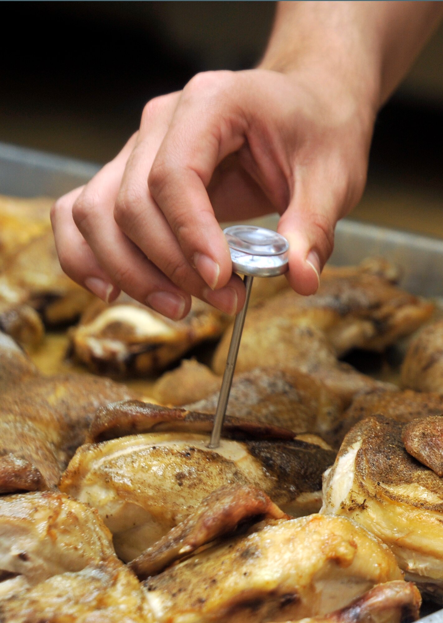 U.S. Air Force Airman 1st Class Stephen Alsvig, 35th Force Support Squadron food services journeyman, checks the internal temperature of baked chicken in the Grissom Dining Facility kitchen at Misawa Air Base, Japan, April 18, 2013. When cooking any type of chicken, food services Airmen must ensure it has an internal temperature above 165 degrees Fahrenheit before it is served. (U.S. Air Force photo by Airman 1st Class Zachary Kee)