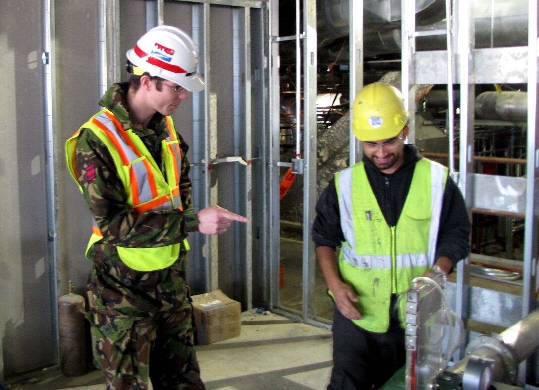 Capt. Ben Hancock (left) works with a Fort Detrick contractor to test ducts at the USAMRIID project to ensure containment and that all specifications are met as part of the quality assurance process. Photo by Brittany Bangert