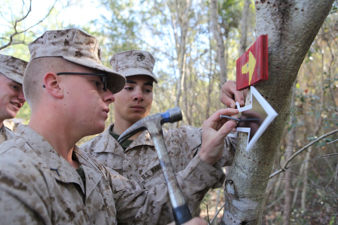 A student of Marine Corps Engineer School hammers a nail into an arrow marking a path in preparation of a Marine Corps Community Service’s St. Paddy’s Day Engineer Challenge run through the Engineers Course March 15. It was the finishing touch in a two-year restoration of the course.