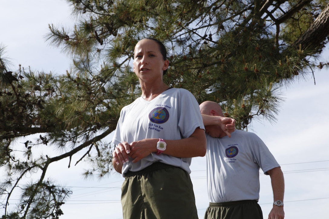 Master Sgt. Amber Beegle, the Navy Marine Corps Relief Society coordinator with the Staff Noncommissioned Officer Academy, speaks to the academy’s troops after the Directors Run, a three-mile fun run held at the end of the school’s course cycles, about the Navy Marine Corps Relief Society during the final week of their fund drive April 18. The school raised more than $500 for the organization through donations and by selling t-shirts for the run.