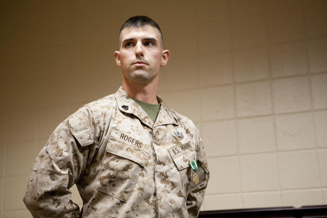 Sgt. David Rogers, an instructor at School of Infantry-East, listens to a speaker after being awarded the Navy Marine Corps Commendation Medal March 25. Rogers and his wife, Anastasia Rogers, saved a man’s life by performing cardio pulmonary resuscitation.