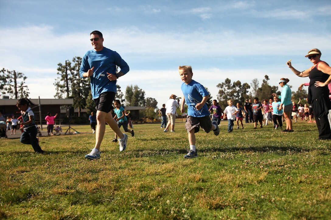 Staff Sgt. Justin Hensley, a data chief with Communications Company, 7th Engineer Support Battalion, and a native of Louisville, Ky., gets La Paloma Elementary School students warmed up before the school’s jog-a-thon, May 3, 2013. Ten Marines with Combat Logistics Regiment 17 and 7th ESB spent the afternoon running with students from kindergarten through sixth grade in order to 
motivate and make the children’s experience more memorable.
