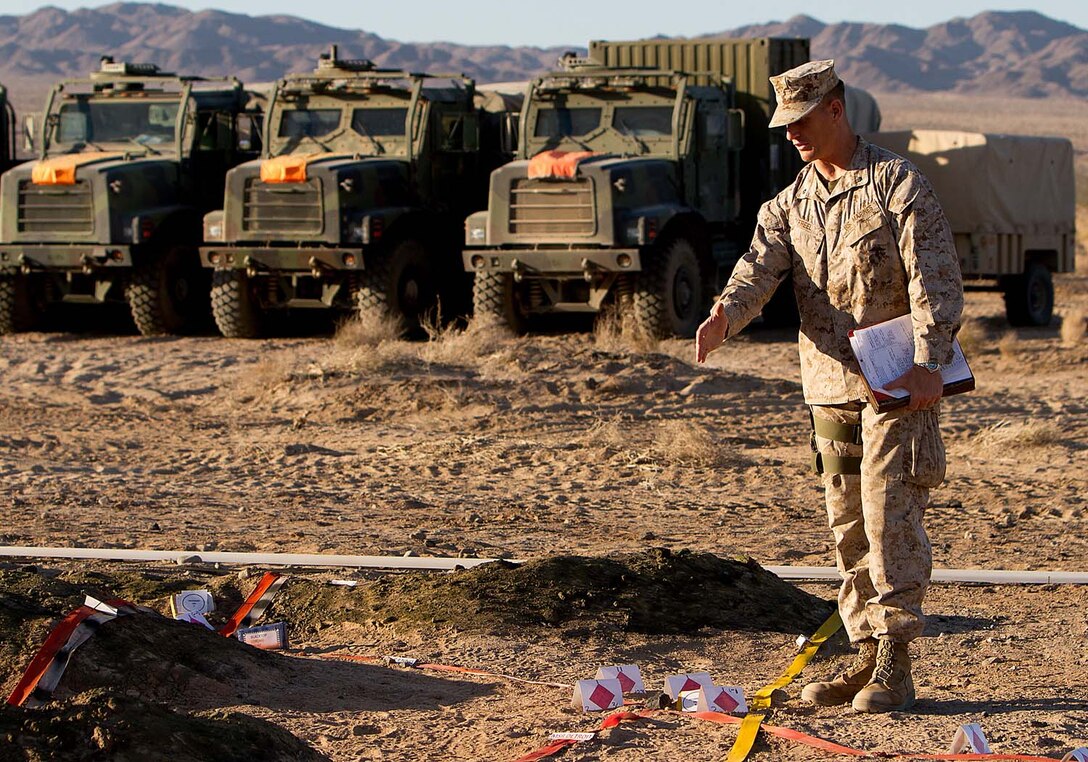 Lieutenant Col. Thomas Freel, the future operations officer for 5th Marine Regiment, 1st Marine Division, points out notional enemy locations on a terrain model for a rehearsal of concept drill during Exercise Desert Scimitar here, May 2, 2013. Desert Scimitar is a combined arms exercise focused on the training and preparation of 1st Marine Division for deployment as the ground combat element of a Marine Air-Ground Task Force. Freel, a native of Grosse Ile, Mich., said the exercise is a return to live-fire combined arms tactics training which has been overshadowed by the focus on counterinsurgency operations training throughout the past decade. The "Fighting Fifth" exercised traditional warfare command and control tactics over infantry, artillery and armored assets during Desert Scimitar.