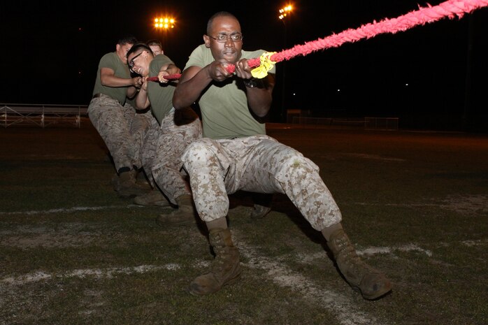 Master Sgt. Lionel Saulsberry, station postal chief, and other servicemembers with Headquarters and Headquarters Squadron, pull with all their strength during the tug of war field meet portion of an overnight field exercise at Penny Lake field here April 18, 2013. The field meet consisted of several events such as the dizzy izzy, Humvee pull and tug of war.