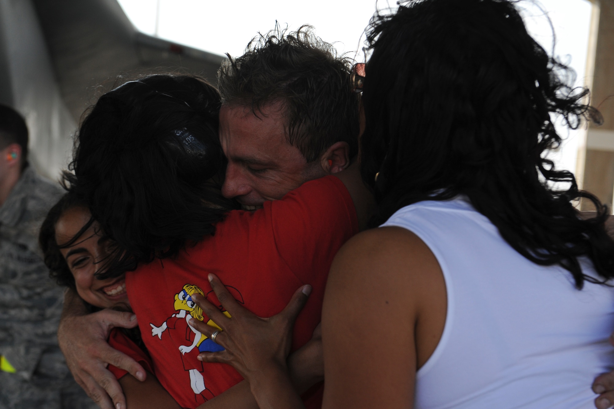 U.S. Air Force Lt. Col. Morris Fontenot, 67th Fighter Squadron commander, embraces his family after returning to Kadena Air Base, Japan, May 8, 2013, after an eight-month deployment. Family members and friends wore an article of red clothing to show support and pride for the squadron during the homecoming. (U.S. Air Force photo by Airman 1st Class Malia Jenkins/Released)