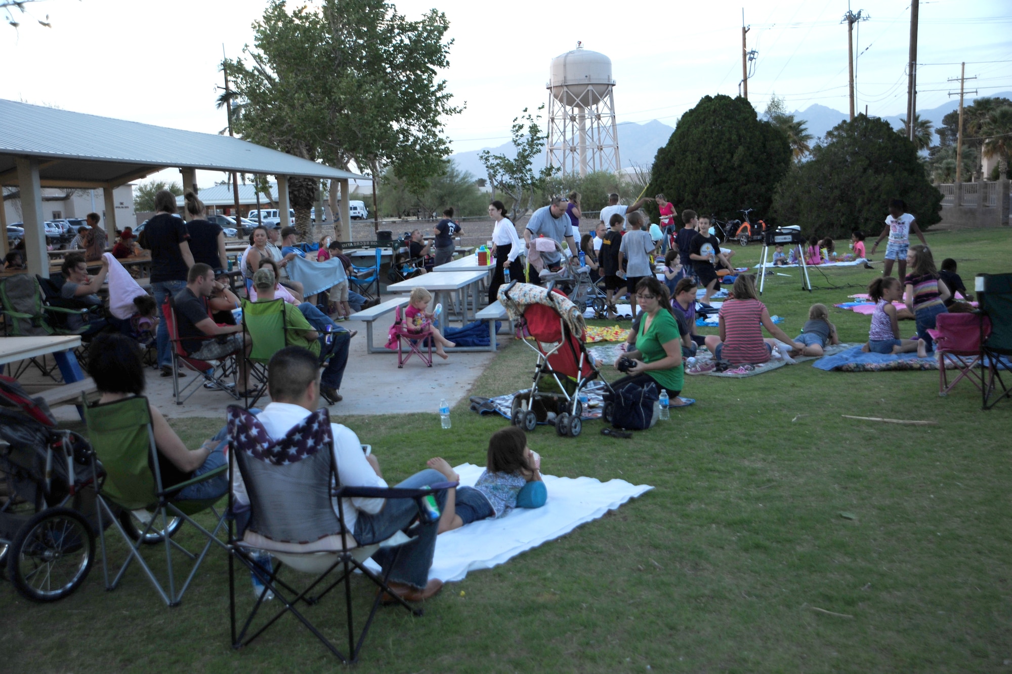 Families get comfortable in Bama Park while anticipating the start of “Monsters Inc.” May 4, 2013 at Davis-Monthan Air Force Base, Ariz. The Movie-in-a-Park event was put on by the Culture of Responsible Choices to give families an alternate, fun activity. (U.S. Air Force photo by Senior Airman Camilla Griffin/released)