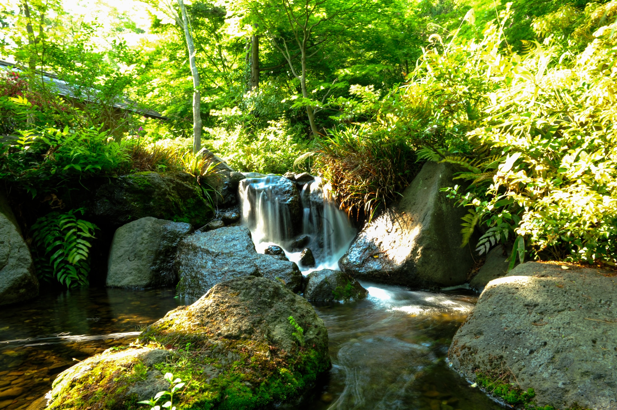 TACHIKAWA, Japan -- Water flows over a small waterfall and into a stream in a Japanese garden at Showa Kinen Park May 5, 2013. Other areas of interest include a bird sanctuary, Komorebi Village and the dragonfly marsh. (U.S. Air Force photo by Senior Airman Michael Washburn/Released)
