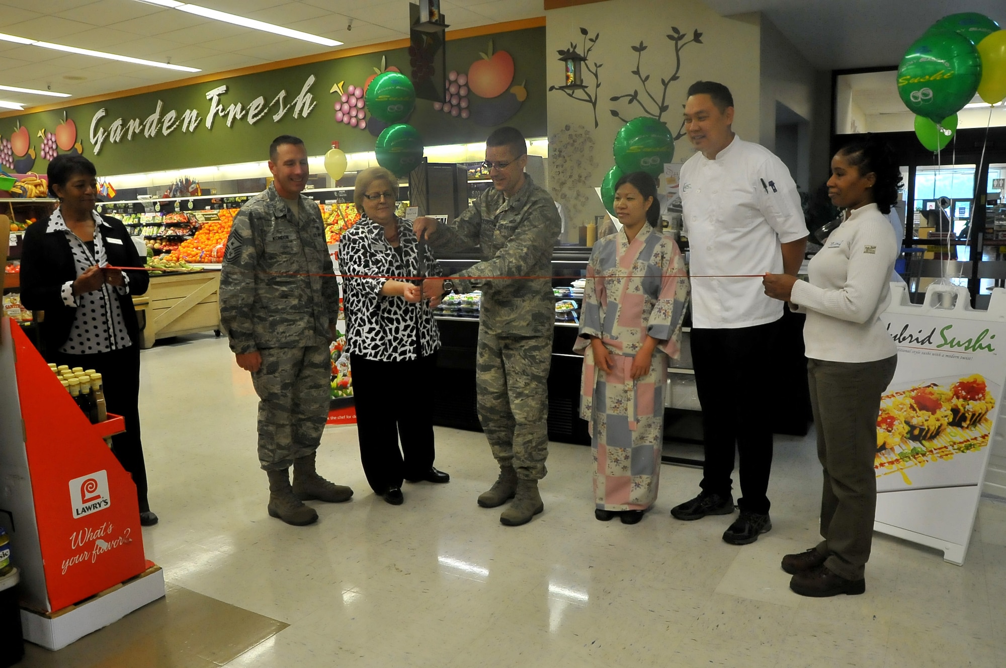 La Vida Nethercutt, Commissary Store Director, and Col. Scott Frickenstein, 14th Mission Support Group Commander, work together to cut the ribbon to symbolize the grand opening of the brand-new sushi bar in the Commissary May 7. The sushi bar will feature freshly-prepared sushi rolls that will be available to patrons as soon as the Commissary opens its doors. (U.S. Air Force Photo by/ Airman 1st Class Stephanie Englar)