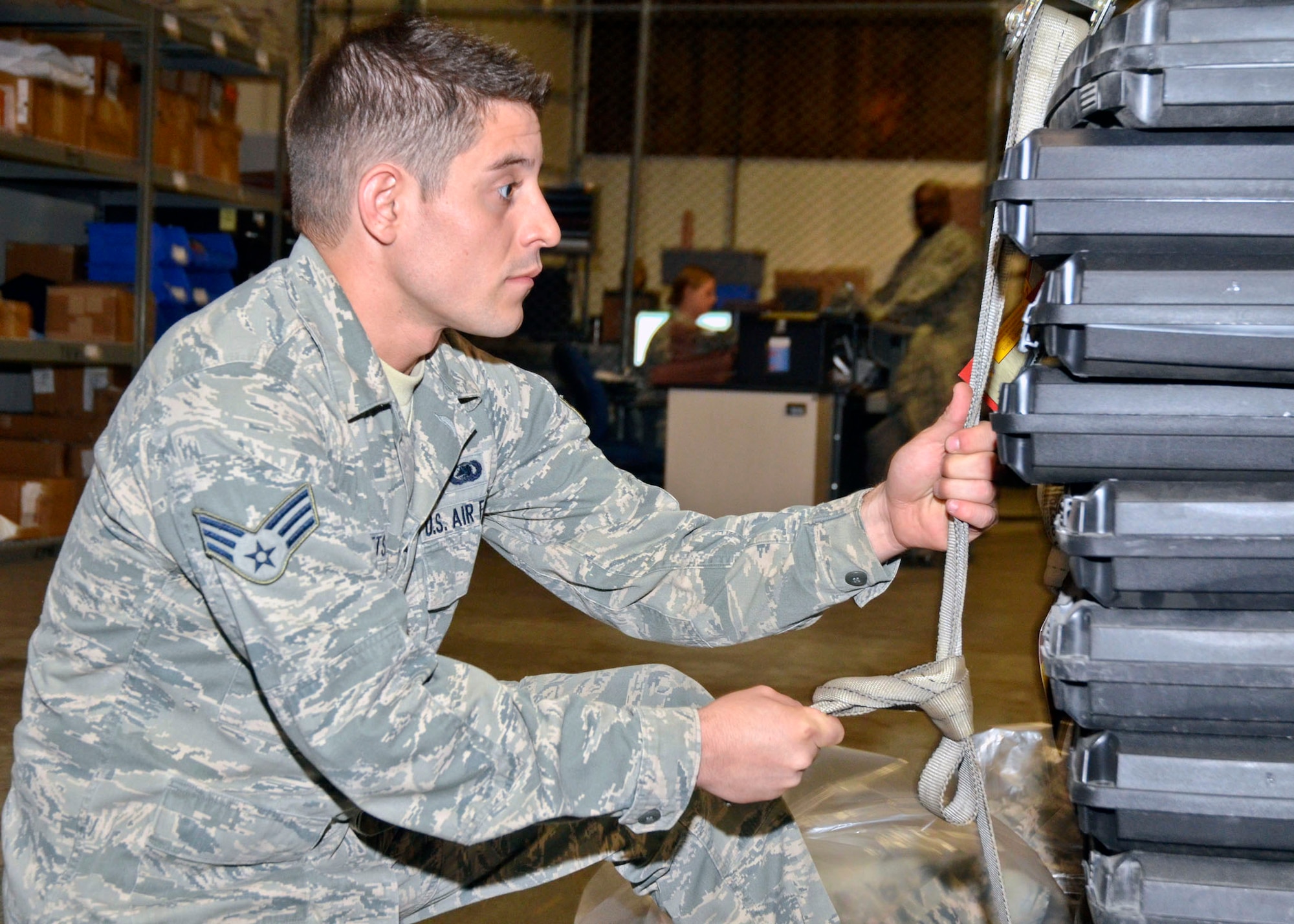 Missouri Air National Guard Senior Airman Adam Catts, of the 131st Logistics Readiness Squadron, secures a cargo strap as he prepares gear for movement during the 131st Bomb Wing’s unit training assembly May 4. (U.S. Air National Guard photo by Staff Sgt. Sean Navarro/RELEASED)