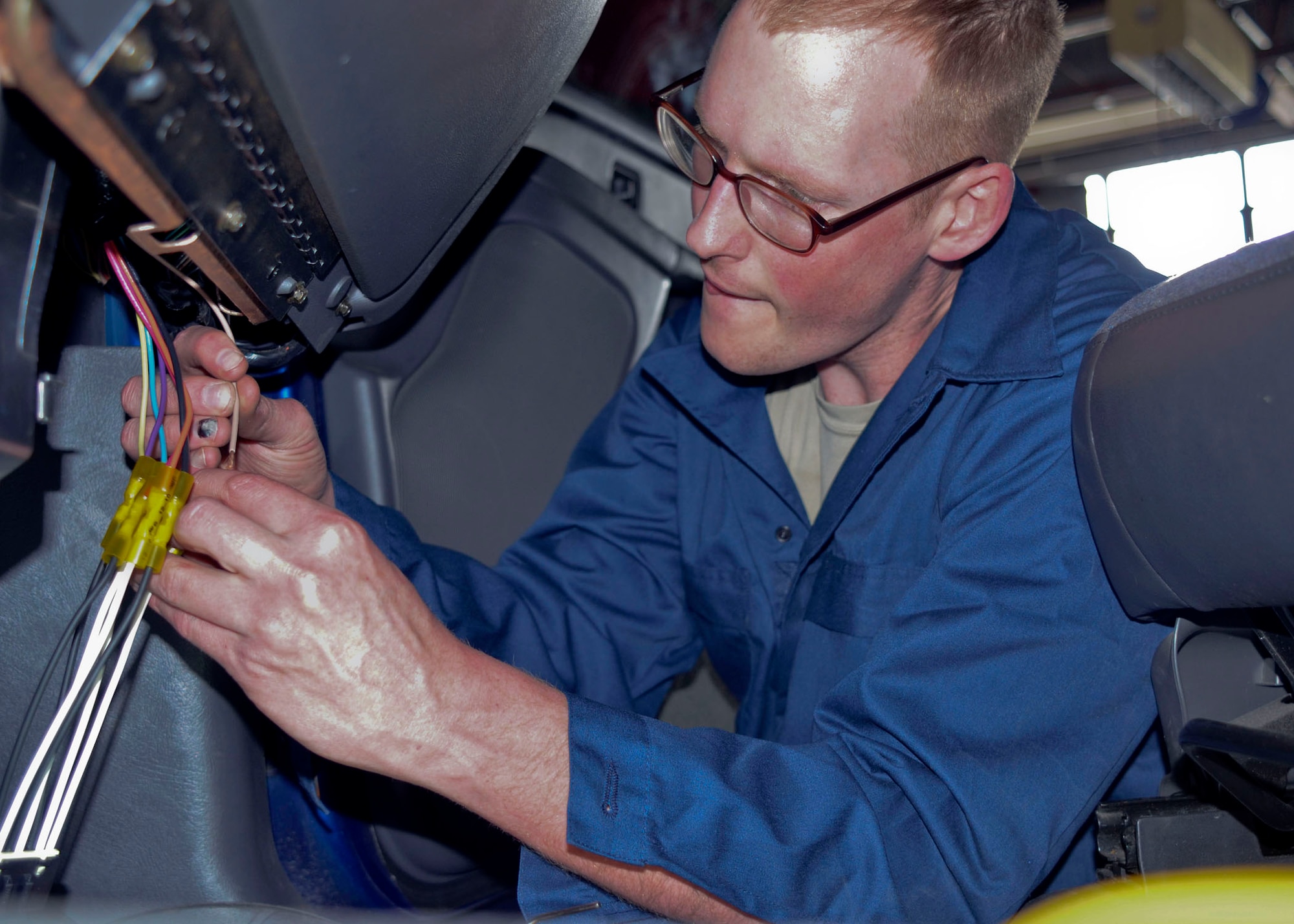 Senior Airman John Long finishes replacing a wiring component in vehicle maintenance during the unit training assembly in May 2013. (U.S. Air National Guard photo by Staff Sgt. Sean Navarro/RELEASED)