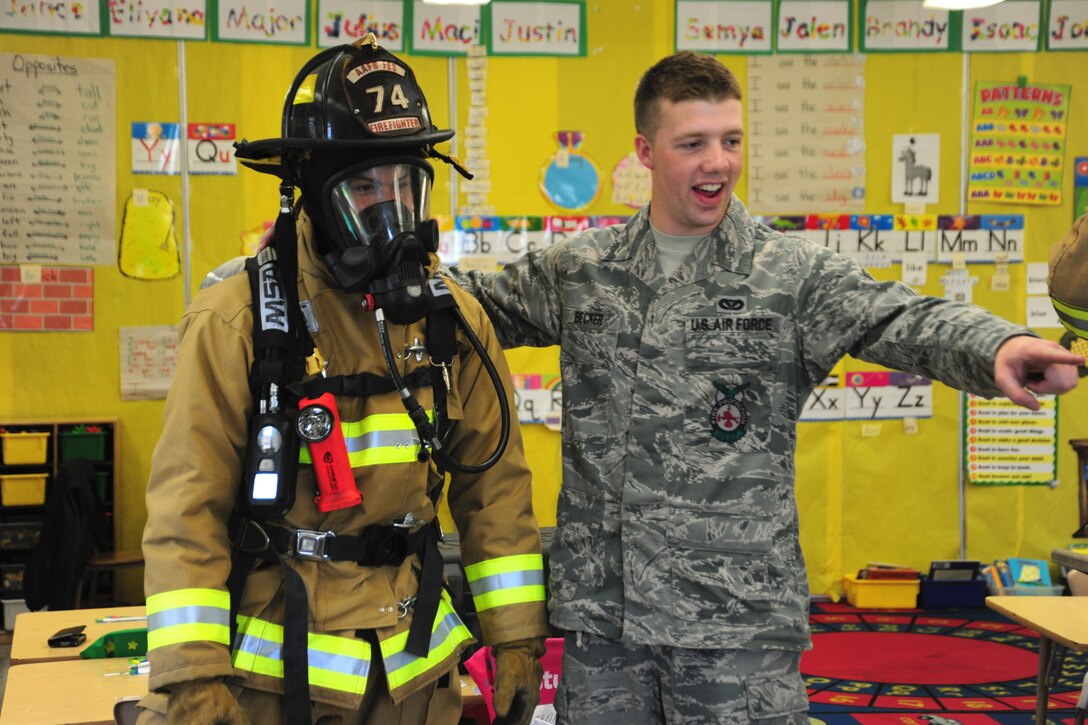 11th Civil Engineer Squadron firefighters, Airmen 1st Class Scott Burdick and Airman Jared Becker answer questions from a kindergarten class May 3, 2013, at a local elementary school career day event. Burdick donned his gear in record time to demonstrate the urgency their career field requires. (U.S. Air Force photo/Staff Sgt. Amber Russell)