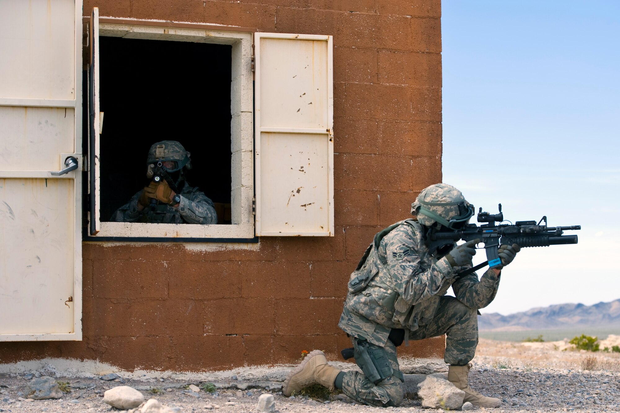 Security forces Airmen guard a building during an urban operations training course April 30, 2013, at Nellis Air Force Base, Nev. During the course, security forces Airmen are evaluated on how they enter buildings, handle detainees, and react to attacks. (U.S. Air Force photo by Airman 1st Class Christopher Tam)