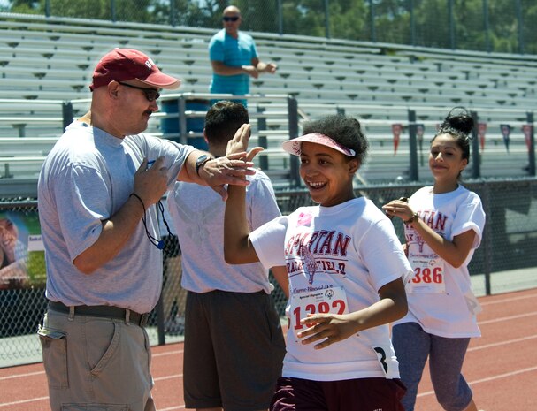 Master Sgt. Mark Peterson, 799th Air Base Squadron, celebrates with a Special Olympian on the 50-meter sprint finish line during the 2013 Special Olympics May 3, 2013, at Cheyenne High School in North Las Vegas, Nev.  Approximately 700 elementary school students and 850 secondary school students participated in the Special Olympics. (U.S. Air Force Photo by Benjamin Newell)