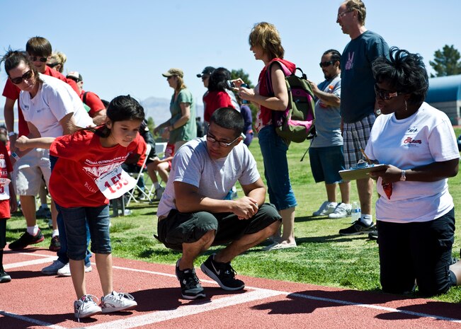 Senior Airman Timothy Ridge, 99th Force Support Squadron career development technician, assists a participant during the 11th Annual Nevada Special Olympics May 2, 2013, at Cheyenne High School in North Las Vegas, Nev.  Approximately 80 volunteers from Nellis Air Force Base helped with the event. (U.S. Air Force Photo by Airman 1st Class Jason Couillard)