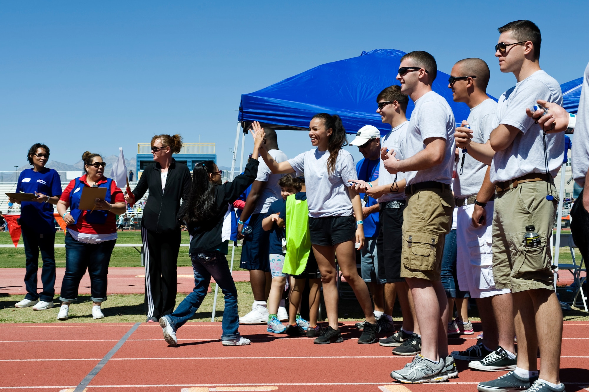 Volunteers from Nellis Air Force Base time and congratulate participants of the 50-meter dash during the 11th Annual Nevada Special Olympics May 2, 2013, at Cheyenne High School in North Las Vegas, Nev. A total of 80 volunteers from Nellis AFB volunteered for this event. The Special Olympics is the world’s largest sports organization for children and adults with intellectual and physical disabilities, providing year round training and competitions to more than 4 million athletes in 170 countries. (U.S. Air Force photo by Airman 1st Class Christopher Tam)