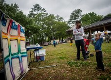 Lindsey Beckenhauer, wife of Capt. Robert Beckenhauer, 16th Airlift Squadron C-17 Globemaster III pilot, watches her son Jake, age 3, play “Tic-Tac-Toss” at the Joint Base Charleston Base Picnic May 3, 2013. The picnic was a free two-day event which included food, drinks and a live band for all Team Charleston members and their families to enjoy. (U.S. Air Force photo/ Senior Airman Dennis Sloan)