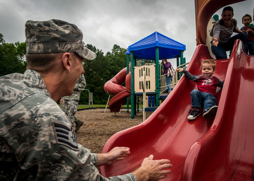 Staff Sgt. Ryan Yeager, 437th Maintenance Squadron Precision Measurement Equipment Laboratory supervisor, kneels down at the end of a slide to catch his son Levi, age 2, while his wife Danielle and Levi’s twin brother Landon send Levi on his way May 3, 2013, at the Joint Base Charleston Base Picnic. The base picnic was a free two-day event which included free food, drinks and a live band for all Team Charleston members and their families to enjoy. (U.S. Air Force photo/ Senior Airman Dennis Sloan)