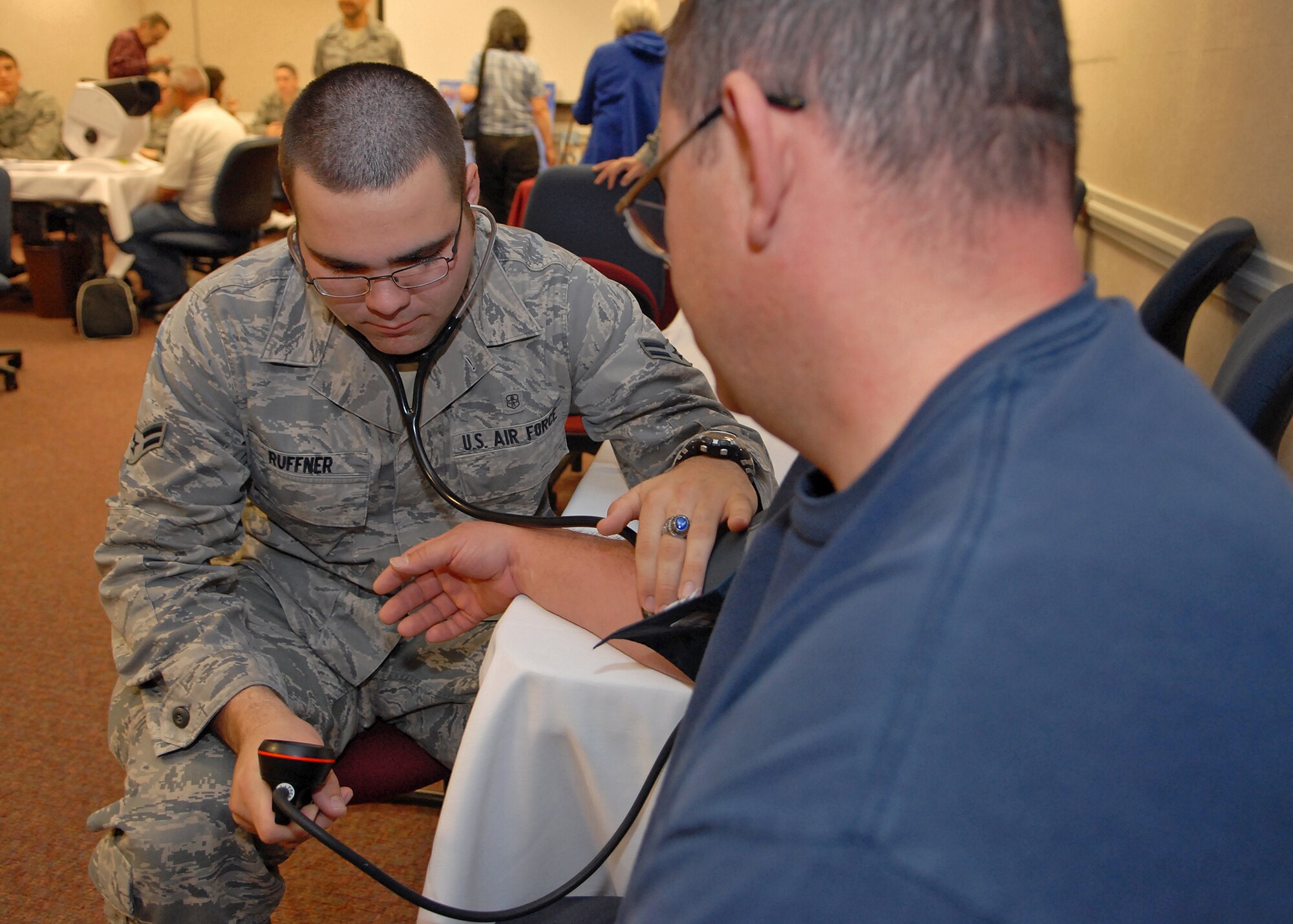 Airman 1st Class Ryan Ruffner, 412th Aerospace Medicine Squadron, checks a retiree's blood pressure during Edwards Air Force Base Military Retiree Appreciation Day May 4, 2013, at the Oasis Community Center. (U.S. Air Force photo by Jet Fabara)