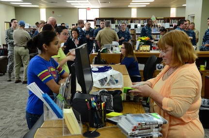 Pamela King (right),Weapons Station Branch Library technician, helps a customer May 7, 2013, at Joint Base Charleston – Weapons Station, S.C. The library recently re-opened after being closed due to renovations. (U.S. Air Force photo/Staff Sgt. Anthony Hyatt)