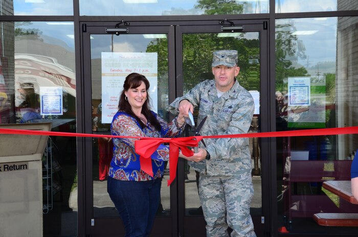 Col. Richard McComb, Joint Base Charleston commander, and Angela Aschenbrenner, JB Charleston Libraries director, cut the ribbon during the grand re-opening of the Weapons Station Branch Library May 7, 2013, at Joint Base Charleston – Weapons Station, S.C. The library re-opened after being closed for renovations in September 2012. (U.S. Air Force photo/Staff Sgt. Anthony Hyatt)