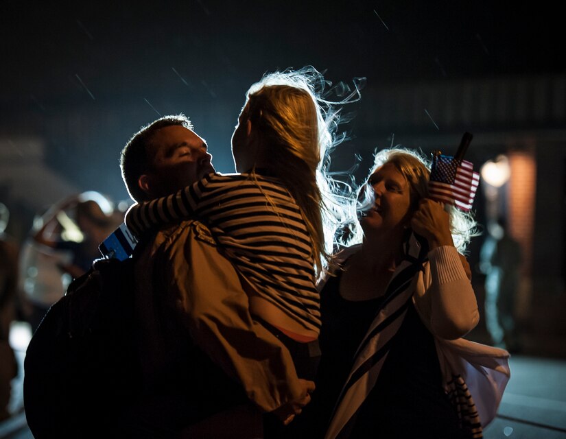 Lt. Col. Dave Owens, 15th Airlift Squadron commander, hugs his 7-year old daughter Katelyn, while his wife Renee watches May 4, 2013, at Joint Base Charleston – Air Base, S.C., after the 15th AS returned from a two-month deployment to Southwest Asia Owens was also met by his 11-year old son Jack. The squadron flew 1,000 sorties while safely moving 40 million pounds of cargo and 5,000 passengers throughout the area of responsibility. The squadron also precisely executed 33 combat airdrops resupplying forward operating bases throughout Southwest Asia with 900 bundles of supplies. (U.S. Air Force photo/ Senior Airman Dennis Sloan)