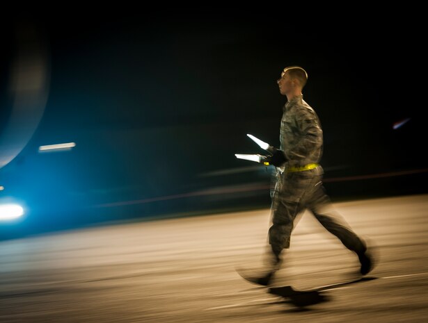 An Airman with the 437th Aircraft Maintenance Squadron guides a staircase truck into place for the Airmen from the 15th Airlift Squadron to deplane the aircraft which returned them to Joint Base Charleston – Air Base, May 4, 2013, after a two-month deployment to Southwest Asia. The squadron flew 1,000 sorties while safely moving 40 million pounds of cargo and 5,000 passengers throughout the area of responsibility. The squadron also precisely executed 33 combat airdrops resupplying forward operating bases throughout Southwest Asia with 900 bundles of supplies. (U.S. Air Force photo/ Senior Airman Dennis Sloan)