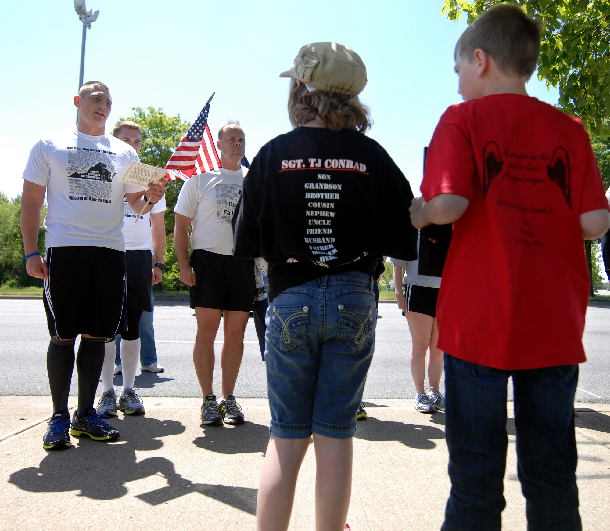 A runner reads off the name of a fallen Serivce member as the family looks on during the “Run for the Fallen” event in Hampton Roads, Va., May 2, 2013. Every branch of service was recognized and represented during the event to support the idea of one force, one fight. (U.S. Air Force photo by Austin Harvill/Released)