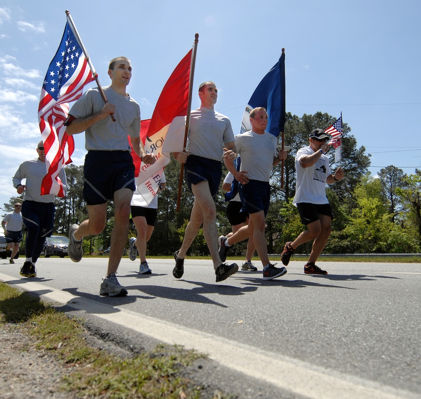 Langley Airmen run with flags in hand during the “Run for the Fallen” event in Hampton Roads, Va., May 2, 2013. With only two weeks’ notice, 20 Airmen signed up to run 15 miles total, and next year they hope to run from the Hampton Roads Bridge Tunnel to Gloucester. (U.S. Air Force photo by Austin Harvill/Released)