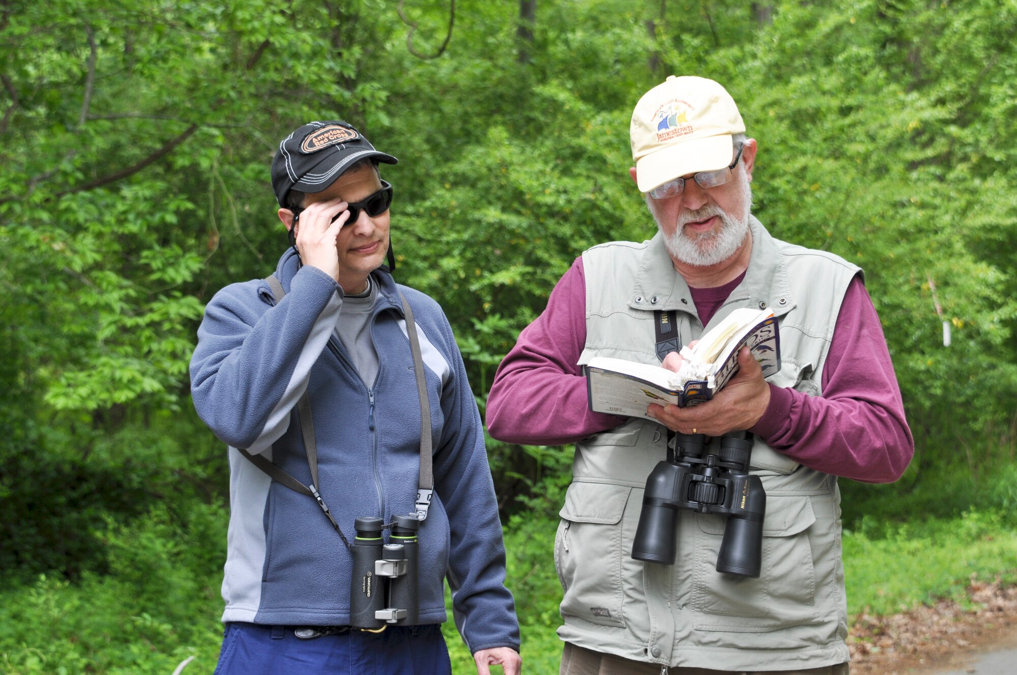 Left to right, William Boeh, bird enthusiast and U.S. Coast Guard preparedness specialist, and Vic Johnston, avid birder and 633rd Air Base Wing public affairs community relations chief, look up information in a bird guide during the Annual Spring Bird Count, May 4, 2013 at Langley Air Force Base, Va.  The two birders conducted the bird count and cataloged 62 species and counted a total of 761 birds. (U.S. Air Force photo by Tech. Sgt. April Wickes/Released)