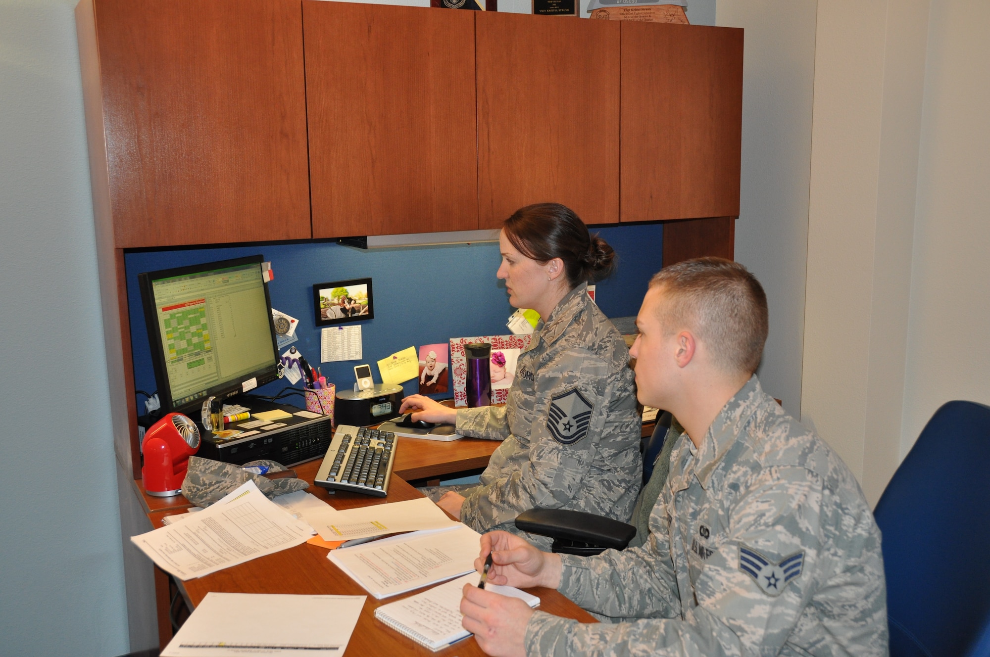 Master Sgt. Kristel Strunk explains the process of reporting fuels data off of local sorties to Air Force Reserve command to Senior Airmen Tyler Walter. In an effort to become more efficient the three F-22 squadrons in Alaska have morphed into a super squadron and Strunk is in charge of combining the fighter squadrons Aviation Resource Management shops. Both Walter and Strunk are Reservists assigned to the 302nd Fighter Squadron ARM shop. (U.S. Air Force photo/Capt. Ashley Conner) 