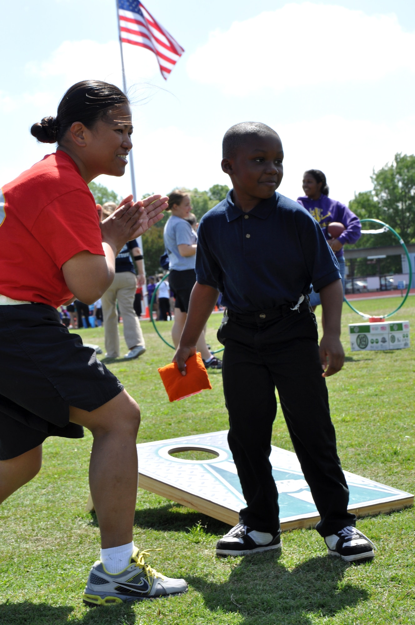 Sgt. Grace Jenkins with the 689th Rapid Port Opening Element, cheers for a participant during a game of bean bag at the George Green 42nd Annual Special Education Field Day, April 2, 2013 at John B. Todd Stadium in Newport News, Va. Soldiers helped 700 children participate in more than 35 events, such as corn hole, flying disc, cup stacking, giant-ball rolling, and relay races. (U.S. Air Force photo by Tech. Sgt. April Wickes/Released)
