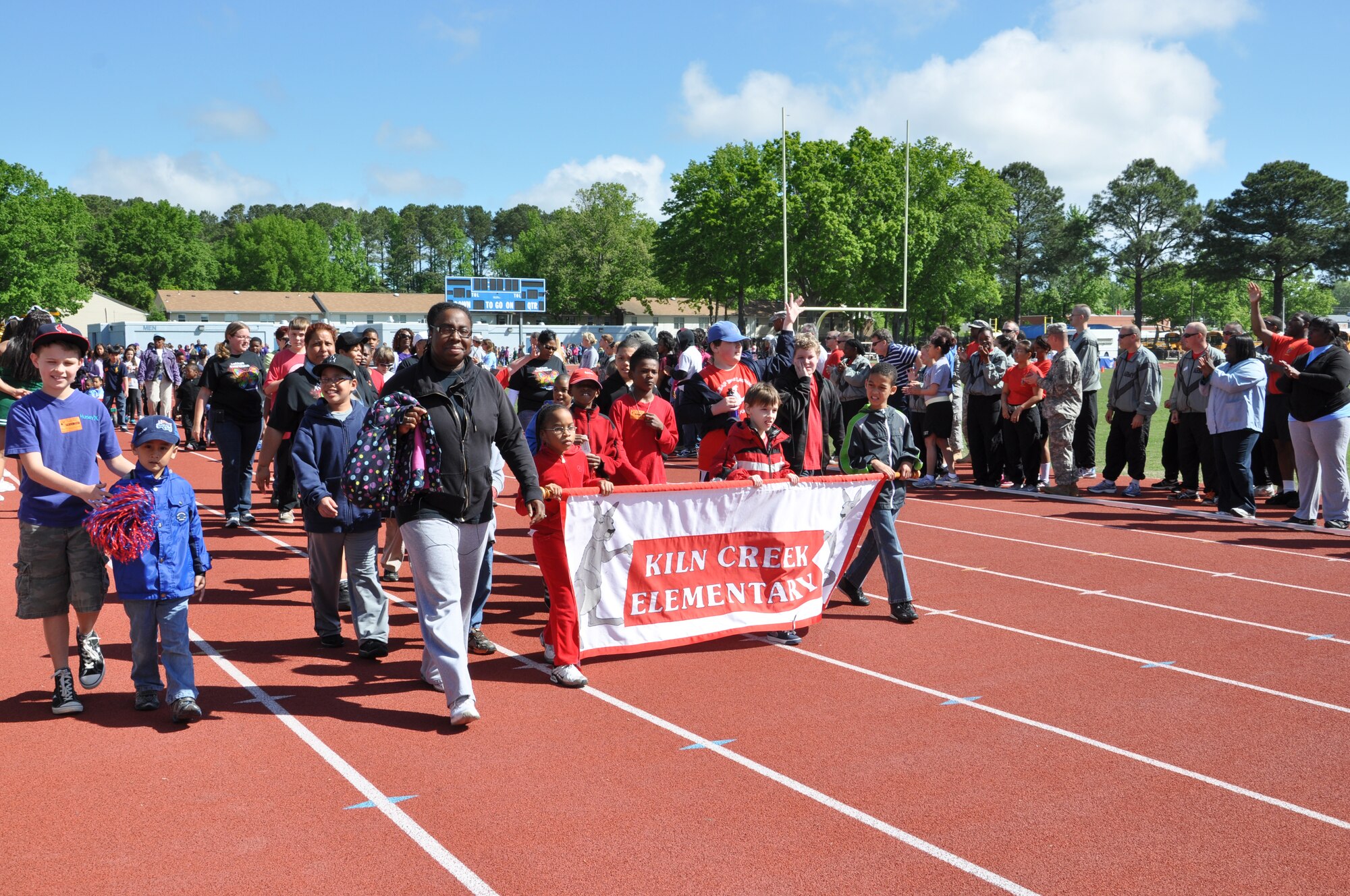 Children from Kiln Creek Elementary school march in a parade during the George Green 42nd Annual Special Education Field Day, April 2, 2013 at John B. Todd Stadium in Newport News, Va. More than 40 Army Soldiers from the 689th Rapid Port Opening Element and the 690th RPOE were on hand volunteered to help 700 children from more than 20 schools participate in the event. (U.S. Air Force photo by Tech. Sgt. April Wickes/Released)