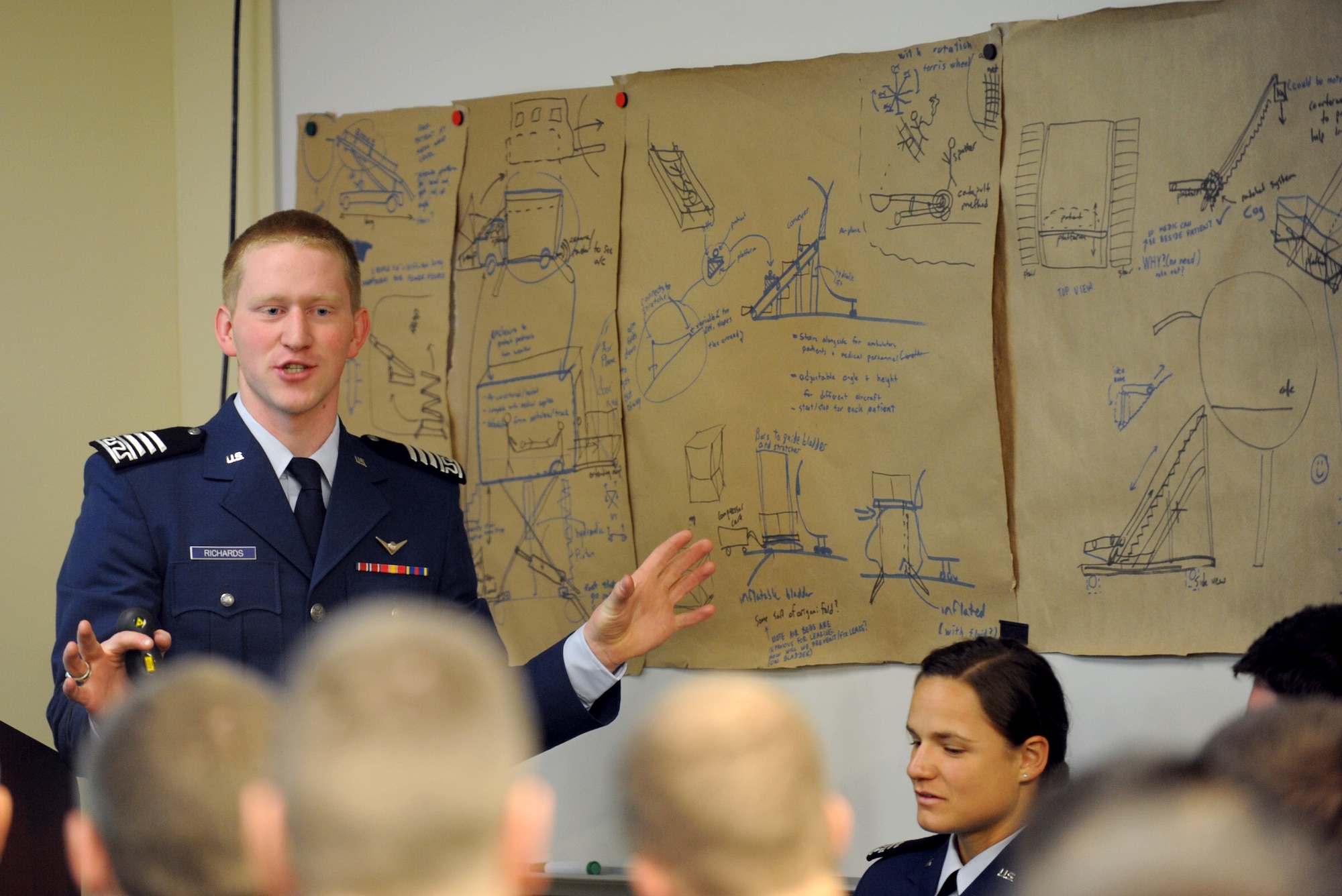 Cadet 1st Class Hayden Richards shows 375th Aeromedical Evacuation Squadron members the brainstorming process the cadets went through to come up with patient loading system prototypes May 3.  During the presentation, the cadets talked about the new enhancements to the current PLS, which they have been working on since their last presentation in January.  (U.S. photo/Staff Sgt. Maria Bowman)
