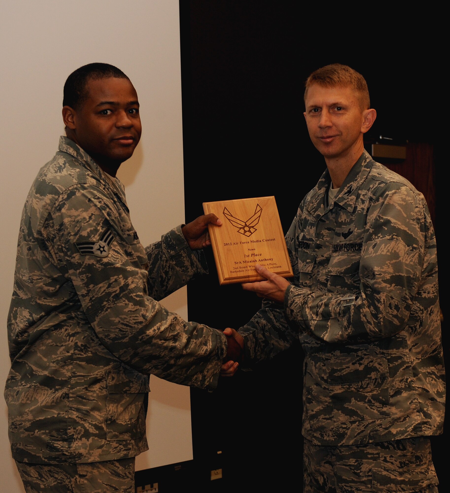Senior Airman Micaiah Anthony, 2nd Bomb Wing Public Affairs, receives the 2012 Air Force Media Award for best news photo from Col. Reid Langdon, 2nd Bomb Wing vice commander, on Barksdale Air Force Base, La., May 8, 2013. Anthony also received the 2012 Air Force Media Award for best personality portrait. (U.S. Air Force photo/Airman 1st Class Benjamin Gonsier)