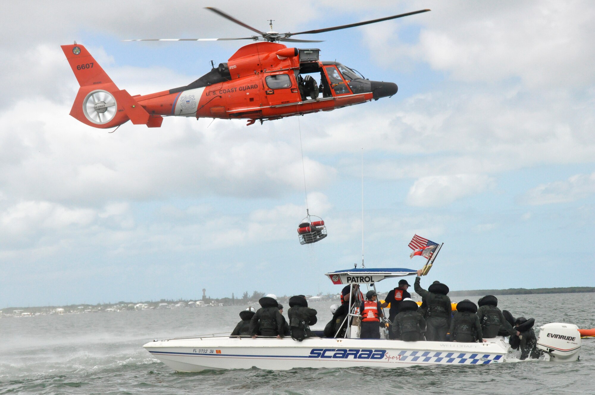An HH-65 helicopter from Coast Guard Air Station Miami extracts a 93rd Fighter Squadron pilot from the waters off of Key Largo while others look on during water survival training May 5. The training was part of a two-day event that included signaling, survival kit familiarization, land navigation and land and water survival training. (U.S. Air Force photo/Staff Sgt. Lou Burton)
