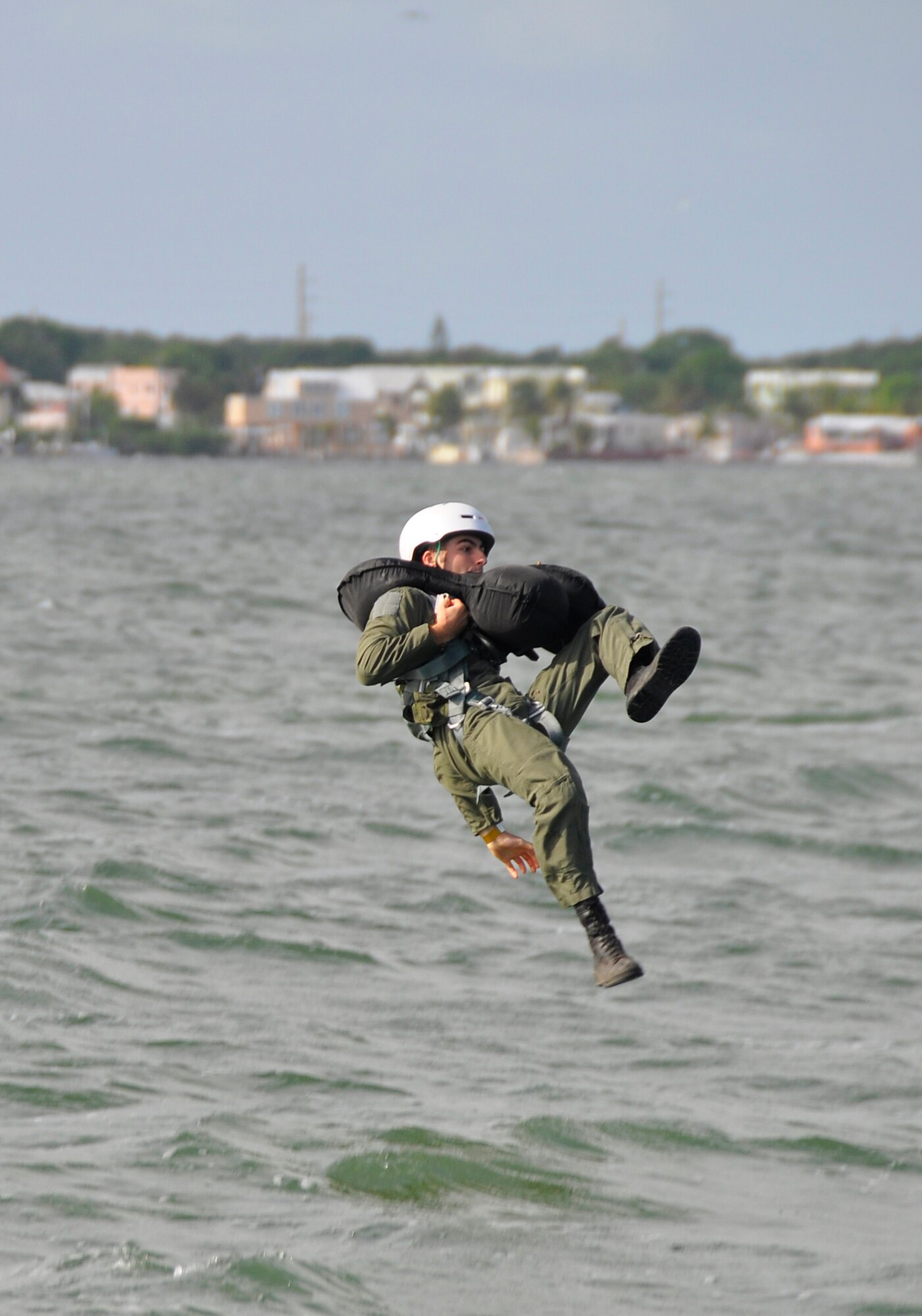 An Airman from Homestead Air Reserve Base, Fla., practices falling into the water after releasing his harness from a parasail during a water survival training May 5. The release simulates an ejected pilot releasing his harness from his parachute. (U.S. Air Force photo/Staff Sgt. Lou Burton) 