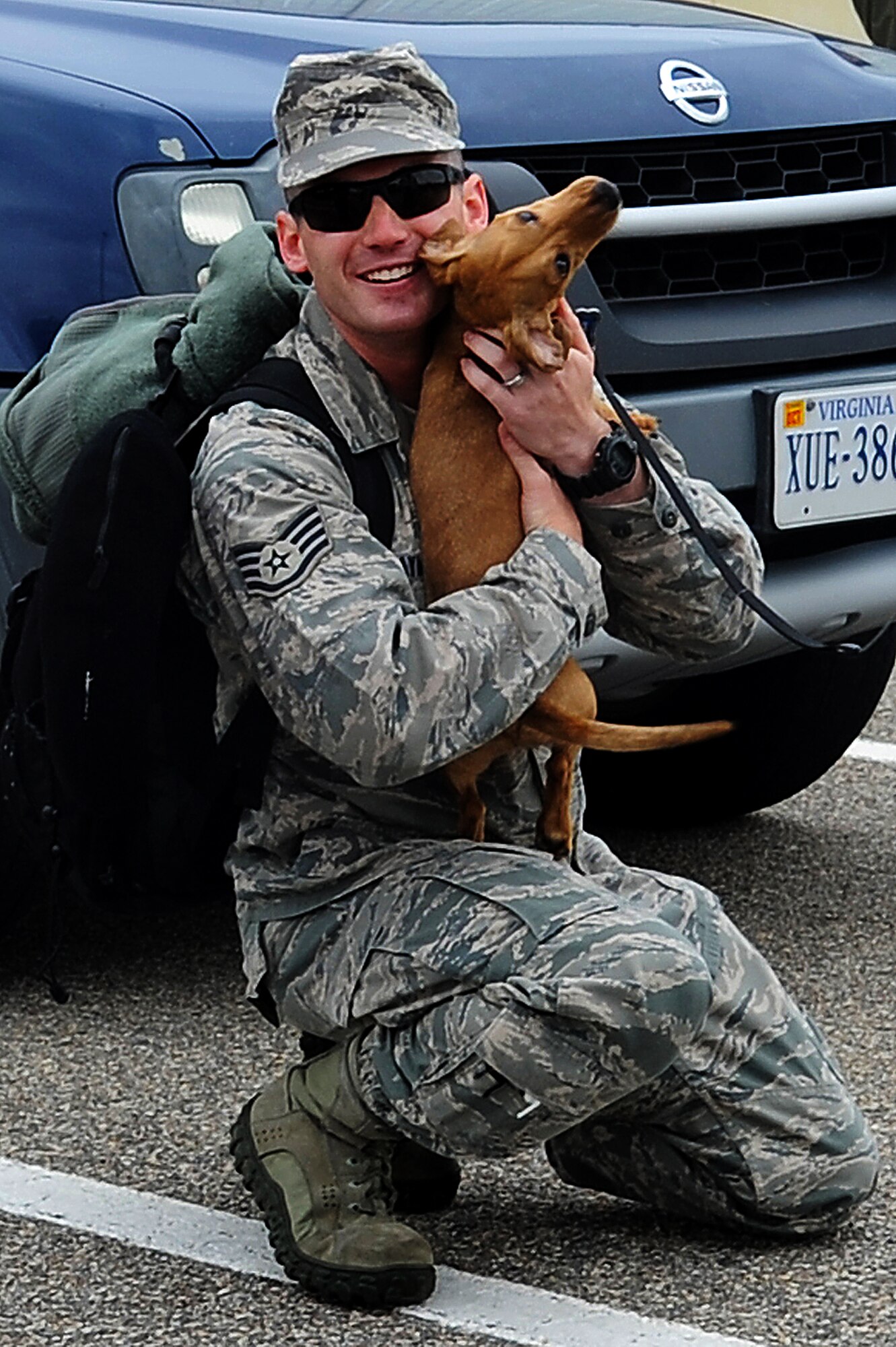 U.S. Air Force Staff Sgt. Jarrett Hayman, 1st Aircraft Maintenance Squadron weapons section supervisor, is greeted by his puppy after returning home from a deployment to Kadena Air Base, Japan. The deployed units performed the mission under the direction of the 18th Wing at Kadena Air Base, Japan. (U.S. Air Force photo by Airman 1st Class Victoria H. Taylor/Released)