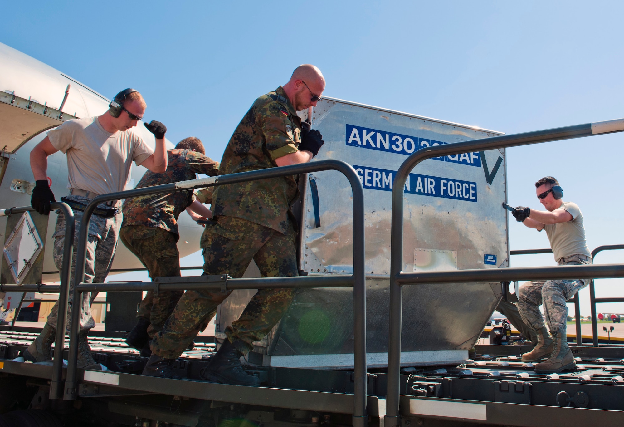 Staff Sgt. Chad Wyffels and Airman 1st Class Evan Green, 728th Air Mobility Squadron air freight crew, and German soldiers move cargo on a Tunner 60K loader May 1, 2013, at Incirlik Air Base, Turkey. German soldiers and 728th AMS members worked hand-in-hand to aid the Germans in their deployment turnover to support NATO’s Patriot mission in Turkey. (U.S. Air Force photo by Senior Airman Daniel Phelps/Released)