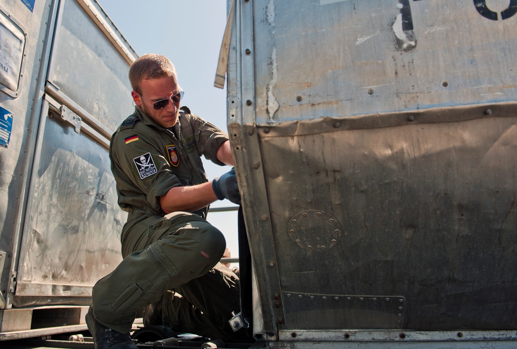 A German service member straps down cargo onto a Tunner 60K loader May 1, 2013, at Incirlik Air Base, Turkey. The German soldiers were switching out with other soldiers to support NATOs commitment to Turkey’s solidarity. They were aided by the 728th Air Mobility Squadron while loading and unloading cargo. (U.S Air Force photo by Senior Airman Daniel Phelps/Released)