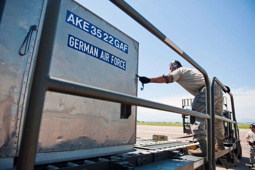 Staff Sgt. Teve Molioo, 728th Air Mobility Squadron air freight supervisor, adjusts cargo on a Tunner 60K loader for the German army as Tech. Sgt. Christopher Dungca, 728th AMS air freight NCO in charge, ensures everything is in line May 1, 2013, at Incirlik Air Base, Turkey. The 728th AMS provides around-the-clock support for U.S. and NATO forces. (U.S. Air Force photo by Senior Airman Daniel Phelps/Released)