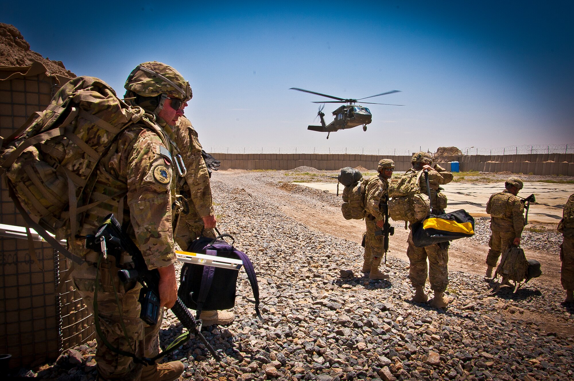 Members of the 577th Expeditionary Prime Base Engineer Emergency Force Squadron Consolidated-Small Maintenance and Repair Team, wait for a Black Hawk helicopter at Combat Outpost Azimijan Kariz, Afghanistan, April 30, 2013. The C-SMART is one of two teams stationed at Kandahar Airfield, Afghanistan. (U.S. Air Force photo/Senior Airman Scott Saldukas)